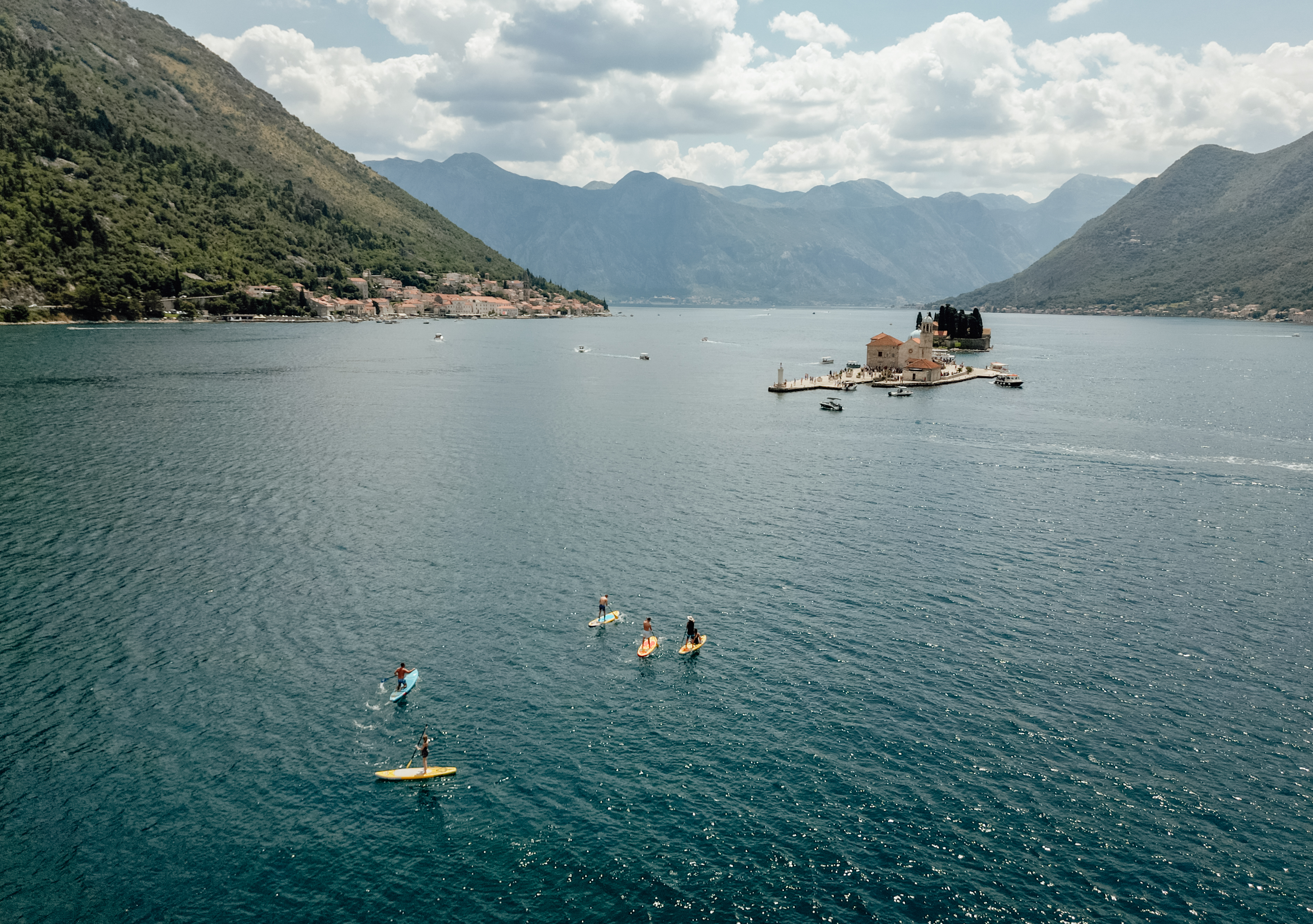 SUP group paddling towards Our Lady of the Rocks island, Perast